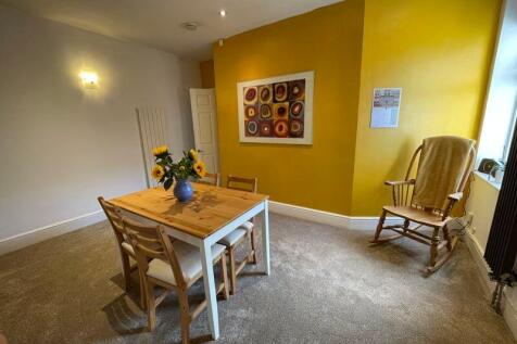 A cozy living room featuring a bright yellow ac...