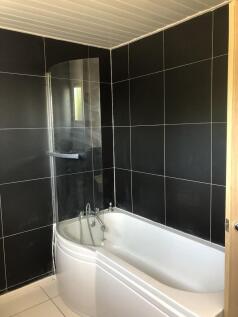A modern bathroom suite featuring a sleek white...