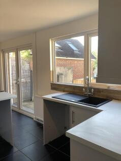Bright kitchen area featuring large windows and...
