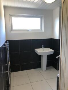 A modern bathroom featuring a clean white sink ...