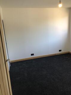An empty room featuring neutral white walls and...