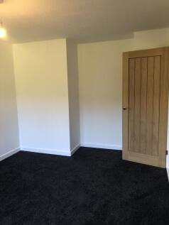 A clean, freshly painted empty room featuring n...