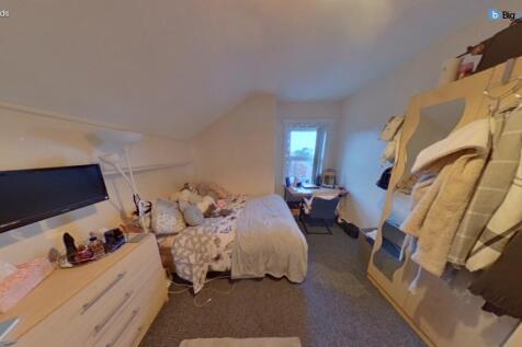 Cozy single bedroom featuring a comfortable bed...