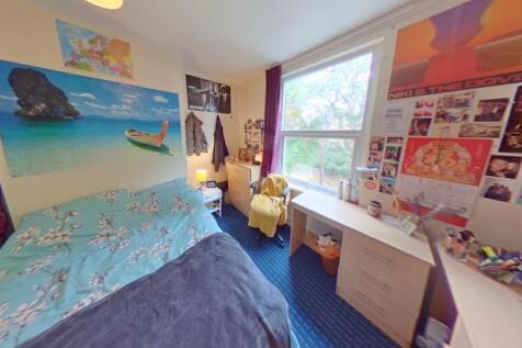 A cozy single bedroom featuring a comfortable b...