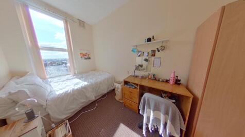 Cozy, bright single bedroom featuring a comfort...