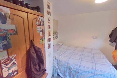 Cozy single bedroom featuring a neatly made bed...