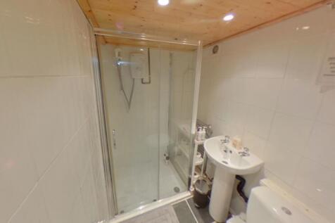 A modern bathroom featuring a glass-enclosed sh...