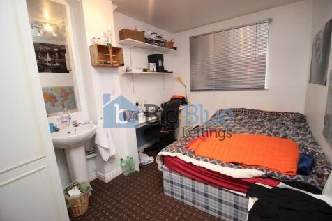 Cozy single bedroom featuring a comfortable bed...