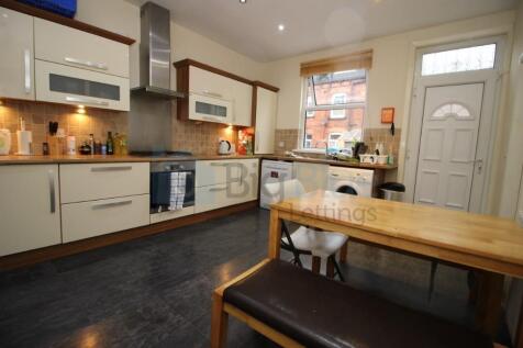 A modern kitchen with cream cabinets, a wooden ...