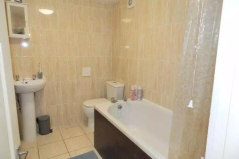 A bright and tidy bathroom featuring a full-siz...