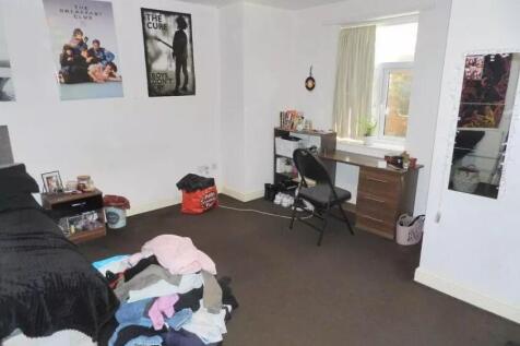A modestly sized bedroom with neutral decor fea...