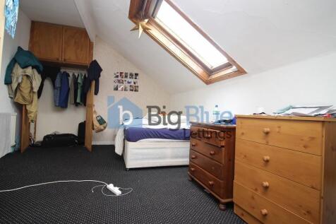 A cozy bedroom featuring a skylight window that...