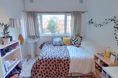 Bright and cozy master bedroom with a large win...