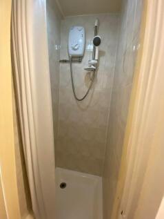 Compact and clean shower area with tiled walls ...