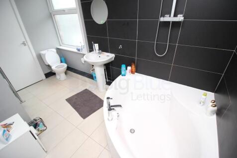 A modern bathroom suite featuring a large corne...