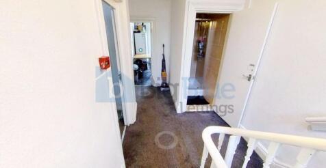 A well-kept hallway with neutral walls and carp...