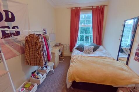 A cozy and well-kept single bedroom featuring a...