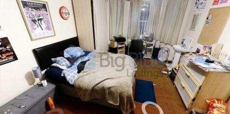 A cozy and well-furnished master bedroom featur...
