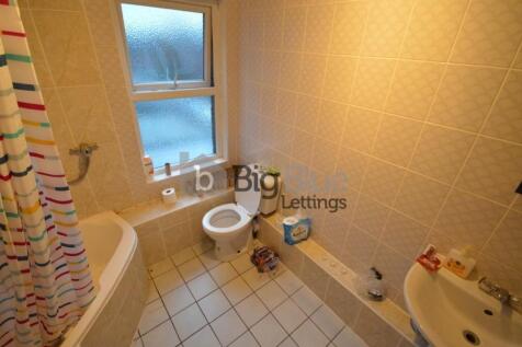 A bright and clean bathroom suite featuring a c...