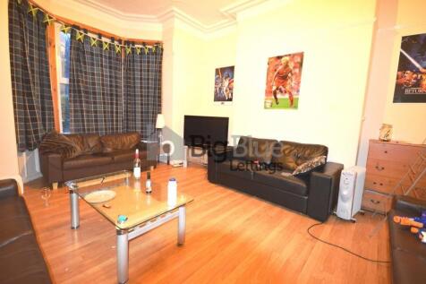 A cozy living room featuring warm wooden floori...