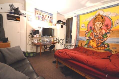 Cozy single bedroom featuring a vibrant Ganesh ...