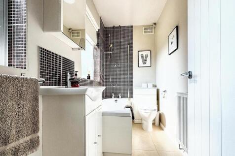 Bright and modern bathroom suite featuring a cl...