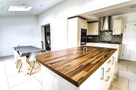 A modern kitchen featuring a spacious wooden is...