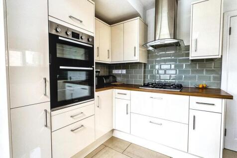 Bright and modern kitchen featuring built-in ov...