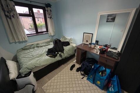 Cozy single bedroom featuring a neatly made bed...
