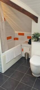 A charming bathroom suite with a unique slanted...