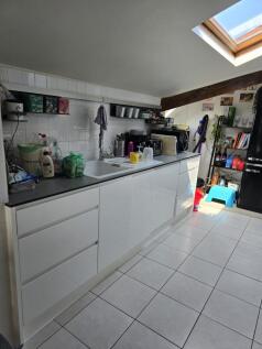 Bright and modern kitchen featuring sleek white...