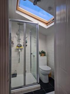 A modern bathroom featuring a glass-enclosed sh...