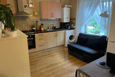 A bright, modern kitchen with wooden cabinetry ...