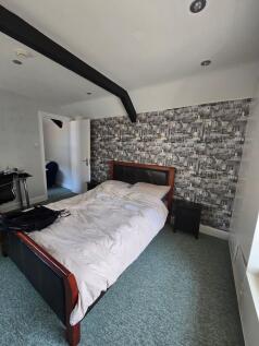 A stylish master bedroom featuring a comfortabl...