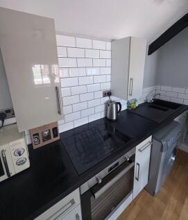 Modern kitchen with sleek black countertops, wh...