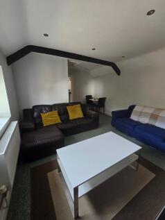 A cozy living room featuring a dark leather sof...