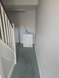 A neat and tidy hallway featuring a carpeted fl...