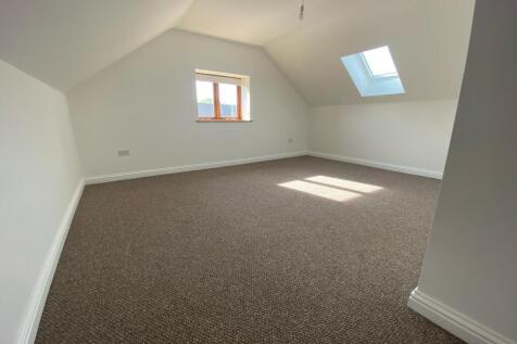 A spacious master bedroom featuring neutral wal...