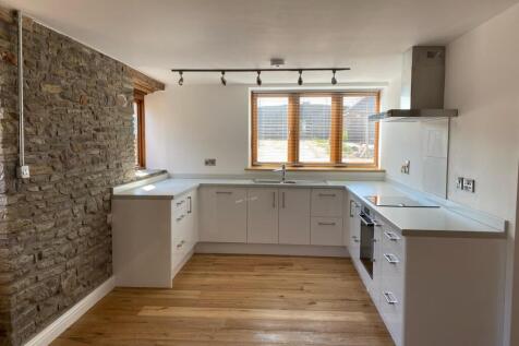 Bright and modern kitchen featuring sleek white...