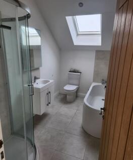 Bright and modern bathroom suite featuring a sp...