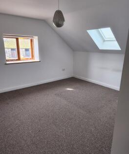 A bright double bedroom featuring a skylight an...