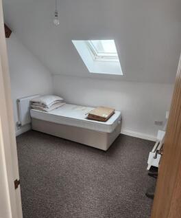 A neat single bedroom featuring a comfortable b...