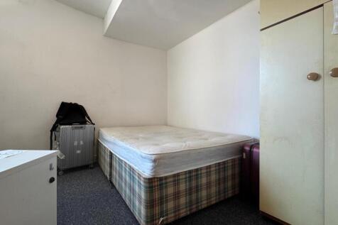 A simple and tidy single bedroom featuring a be...