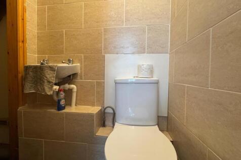 A neat and functional single toilet room featur...