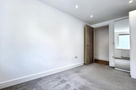 A clean, bright bedroom featuring neutral tones...