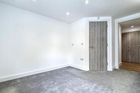 A clean and modern small room with neutral whit...