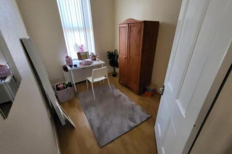 A cozy single bedroom featuring a clean and tid...