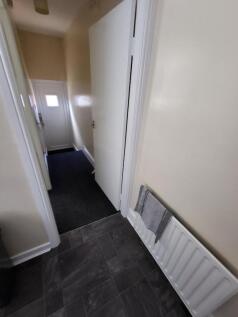 A clean and tidy hallway featuring neutral beig...