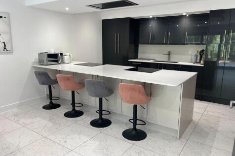 Modern kitchen featuring a sleek white island w...