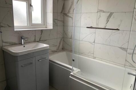 Bright and modern bathroom suite featuring a sl...